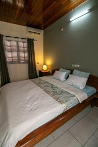 a large bed in a bedroom with a window at Villa NATH - Kribi centre-ville in Elabi