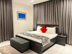 a bedroom with a bed with two red pillows at Orbit Apartments in Lagos