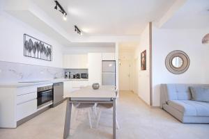 a kitchen and living room with a table and a couch at Luxury 2BR Bauhaus on the beach by HolyGuest in Tel Aviv