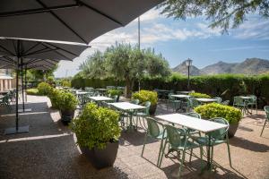 a group of tables and chairs with an umbrella at Balneario de Fitero - Hotel Bécquer in Fitero