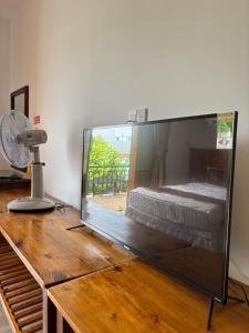 a large flat screen tv sitting on a wooden table at Ambedo Hotel Phu Quoc in Phu Quoc