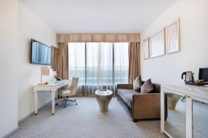 a living room with a couch and a desk at Dorsett Shepherds Bush London in London