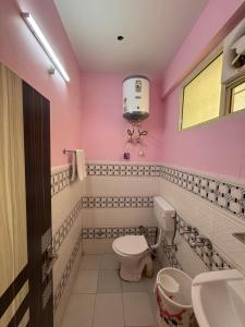 ein rosafarbenes Bad mit einem WC und einem Waschbecken in der Unterkunft Pine View Guest House in Nahan