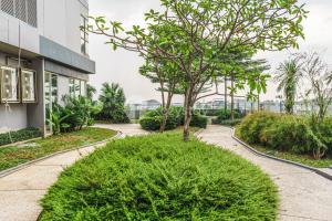 a walkway in front of a building with a tree at Halia by Kozystay - Pondok Indah in Jakarta