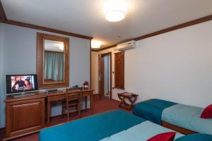 una camera d'albergo con letto e scrivania con TV di Villa Meri a Trogir