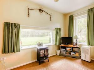 a living room with a window with green curtains at Secluded Holiday Home in Ceredigion with Garden in Pennant
