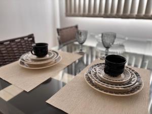 a table with two cups and plates on it at ÓTIMO, funcional e aconchegante! Todos os Santos! in Montes Claros