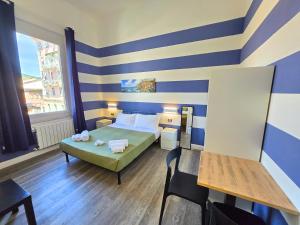 a small room with a bed and a table at Affittacamere Guest House Happy Holiday in La Spezia