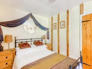 a bedroom with a white bed with a blue drape at Secluded Holiday Home in Ceredigion with Garden in Pennant +37 photos