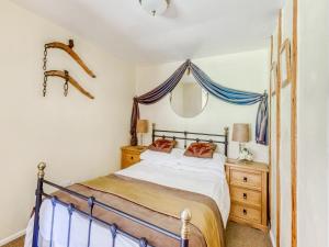 a bedroom with a bed and a mirror on the wall at Secluded Holiday Home in Ceredigion with Garden in Pennant