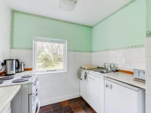 a kitchen with white appliances and a window at Secluded Holiday Home in Ceredigion with Garden in Pennant
