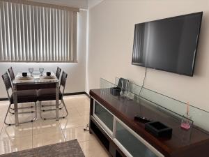 a living room with a table and a flat screen tv at ÓTIMO, funcional e aconchegante! Todos os Santos! in Montes Claros