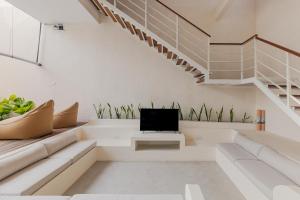 een woonkamer met een bank en een tv bij Arjuna Villa by Betterplace in Dalung