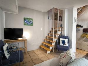 a living room with a couch and a television at Maison des Remparts nichée sous la Cité in Carcassonne