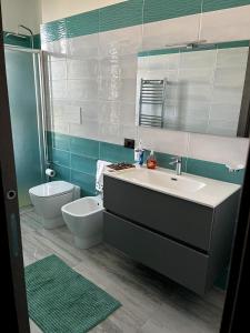 a bathroom with a sink and a toilet at 'C'est la vie' Apartment VR20 in Gela +17 photos