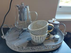 a glass tray with a blender and cups on a table at Kesklinna korter in Kuressaare