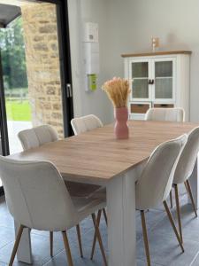 a dining room table with chairs and a vase with flowers at Gulf Stone in Séné