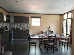 a dining room with a table and chairs in a kitchen at Notwane court in Gaborone