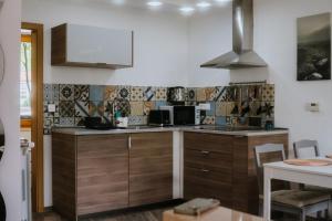 a kitchen with wooden cabinets and a stove top oven at Jakova Hiša in Kobarid