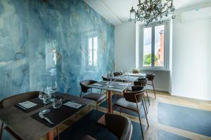 a dining room with tables and chairs and a blue wall at Ariccia Luxury House camere di charme con spa privata per soggiorni romantici in Ariccia