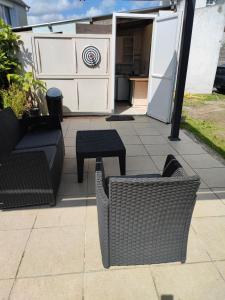 a patio with wicker furniture and a table and a kitchen at Studio Madeleine "endroit calme" in Morlaix +3 photos