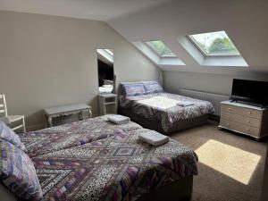 una camera con 2 letti, TV e lucernari di Harmony Inn - Glena House a Killarney