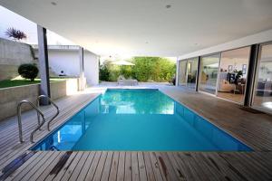 a swimming pool in a house with a wooden deck at Villa 257 in Caminha