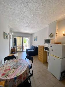 a living room with a table and a kitchen at Appartement SOL in Empuriabrava