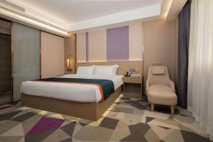 深圳Shenzhen Jincheng Hotel的带一张大床和一把椅子的卧室