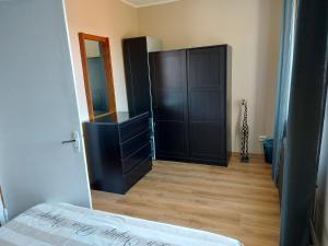 a bedroom with a black door and a wooden floor at Kesklinna korter in Kuressaare