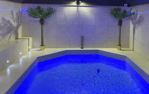 a large blue pool in a bathroom with palm trees at Appart Quartier Louise Bruxelles in Brussels