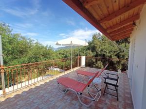 eine Terrasse mit Tisch, Stühlen und Sonnenschirm in der Unterkunft The Vrachos Beach House in Preveza