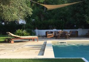 a swimming pool with a table and a hammock next to a pool at Villa CasinaSanDonato in San Donato