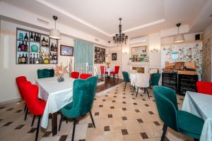 a dining room with a table and green chairs at Rooms Villa Padre in Pag