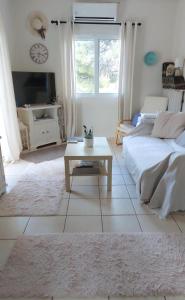 a white living room with a bed and a coffee table at Agia Marina House, walking distance to the beach in Aghia Marina