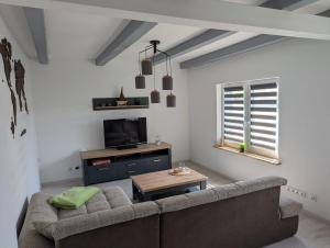 a living room with a couch and a tv at Lütt achtern Diek in Neufeld
