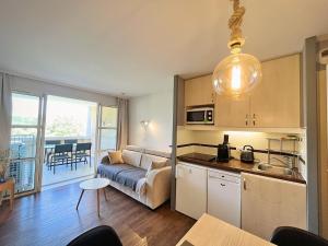 a kitchen and living room with a couch and a table at La Perle Blanche in Saint-Raphaël