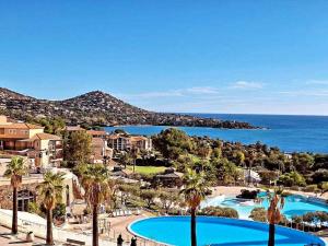 a view of a resort with a pool and the ocean at La Perle Blanche in Saint-Raphaël