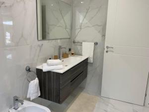 a white bathroom with a sink and a mirror at Villa Serafina in Otranto +7 photos