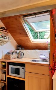 a kitchen with a sink and a window at The Bothy, wood fired hot tub, luxury spa bathroom in St Asaph