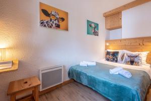 Un dormitorio con una cama con dos toallas encima. en Joli appartement Aiguille du Midi, en Chamonix-Mont-Blanc
