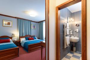 a hotel room with two beds and a bathroom at Villa Meri in Trogir