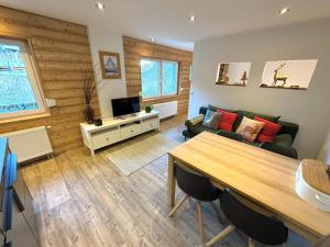 a living room with a couch and a table at Studio in Chalet Lucia - Der Traum am Bach in Leukerbad