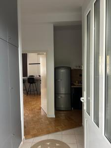a kitchen with a refrigerator in the middle of a room at Apartman Galah in Vukovar