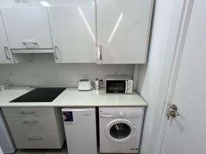 a kitchen with a washing machine and a microwave at Matiko habitaciones in Bilbao