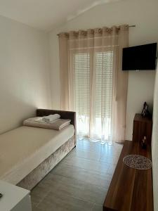 a bedroom with a bed and a large window at MAK apartment in Kaštela