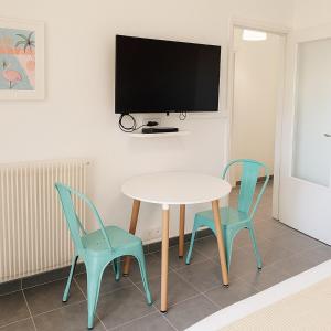 einen Tisch mit 2 Stühlen und einen TV an der Wand in der Unterkunft Appartement de charme à Digoin #14 in Digoin