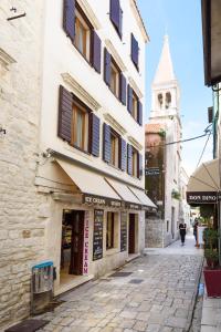 una strada in un centro storico con una torre dell'orologio di Villa Meri a Trogir