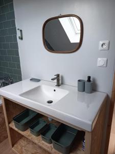 a bathroom with a white sink and a mirror at Gîte - La Maison in Kernascléden +20 photos