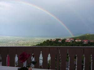 a rainbow in the sky over a balcony at Guest House Maria in Sighnaghi